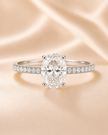 Anillo Solitario Pavé en Oro con Diamante Ovalado de Laboratorio y Diamantes Laterales Naturales